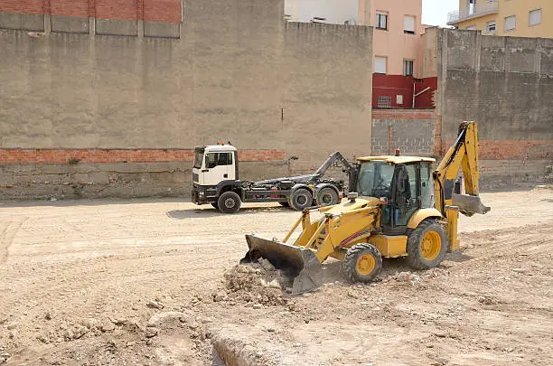 Road,building construction equipment yellow excavator-machine and white truck