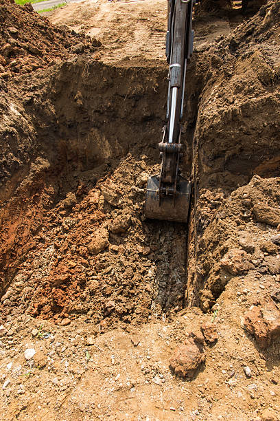 istock digging and leveling the bottom of the backyard septic tank 540825964