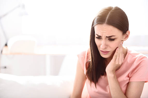 istock Gloomy sick woman sitting on the couch 540829732