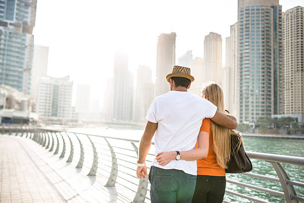 togetherness couple in vacations on Dubai Marina - UAE togetherness couple in vacations on Dubai Marina - UAE dubai marina panorama stock pictures, royalty-free photos & images