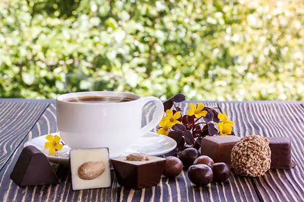 Dark chocolate,candy and cup of coffee  on a wooden table
