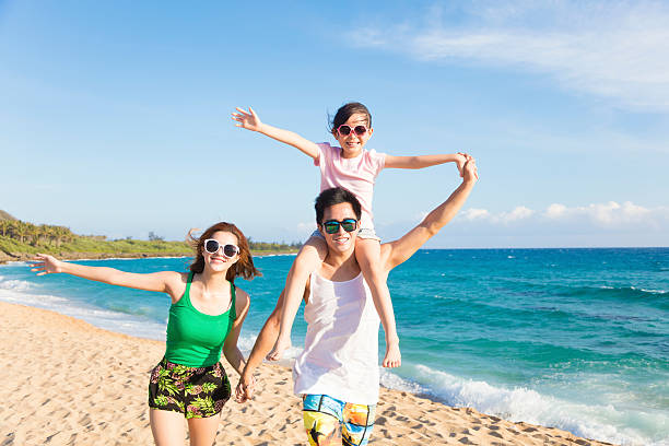 istock happy young family walking on the beach 540838600