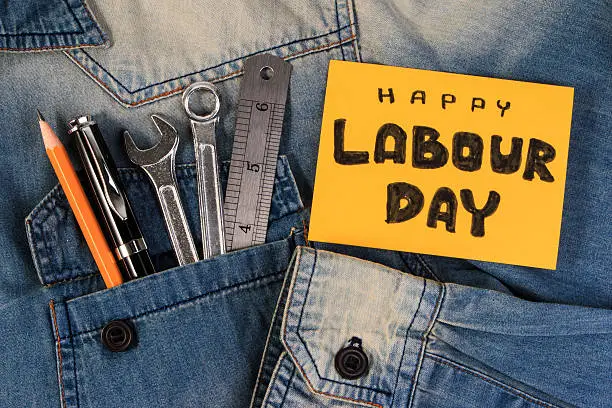 Photo of Wrench tools on a denim workers. Happy Labour Day.
