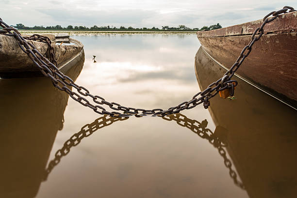 Small fishing boat is parking on bay in sunset after fisherman work all day. It is life style of almost people in water resource area. The image showing beautiful sky and reflection on water surface.