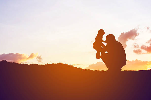 istock father encouraged her son outdoors at sunset, silhouette concept 540843626