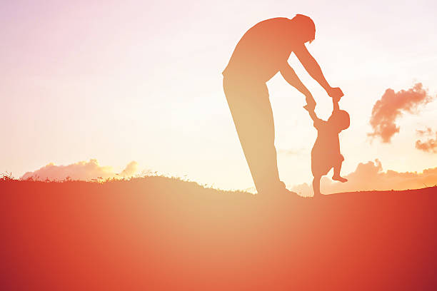 istock father and little daughter walking at sunset 540843680
