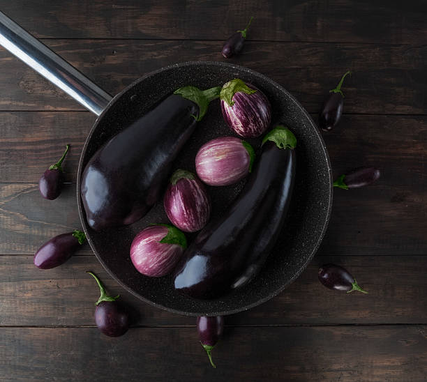 istock Whole eggplants on frying pan top view 540844158
