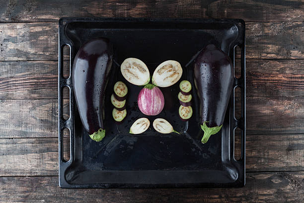 istock Whole and sliced eggplants on baking tray 540844226