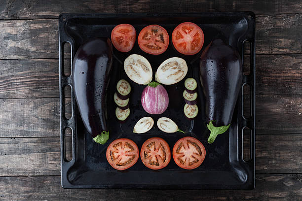 Whole and sliced eggplants and tomatoes.