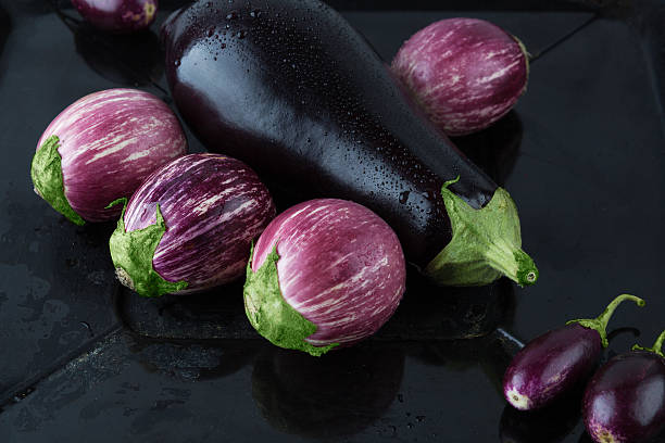 istock Wet eggplant varieties on rustic frying pan closeup 540844788