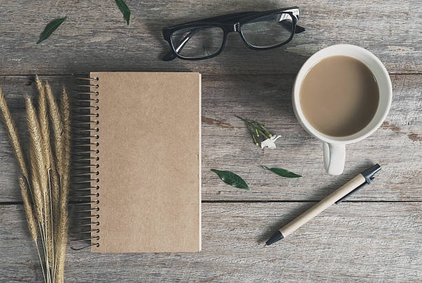 istock Cup of coffee with notebook on wooden table 540847332