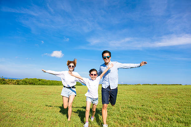 famiglia felice che corre insieme sull'erba - spring child field running foto e immagini stock