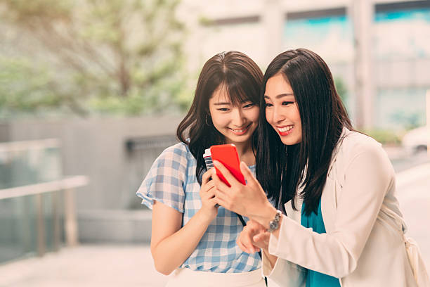 istock Smiling Asian Ethnicity girls texting 540854538