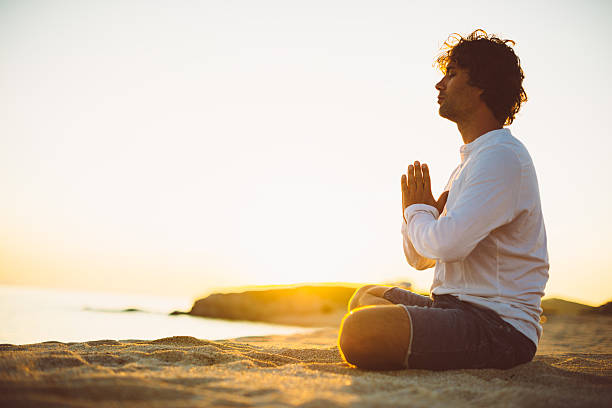 praticare yoga e meditazione in estate sulla spiaggia al tramonto - sunset yoga young men caucasian foto e immagini stock