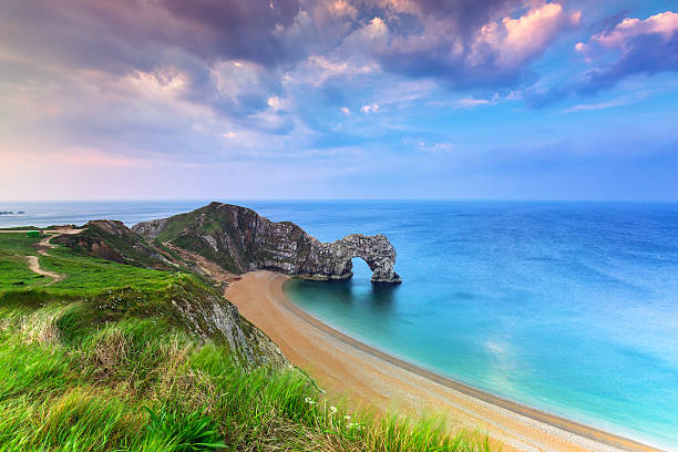Durdle Door at the beach of Dorset, UK Jurassic Coast of Dorset with Durdle Door at sunrise , UK durdle door stock pictures, royalty-free photos & images