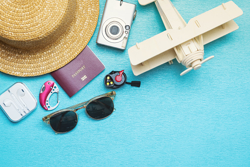 Accessories for travel. Passport, Earphone, sunglasses, Headlamps, hat, camera and a plane. Top view. Holidays and tourism concept