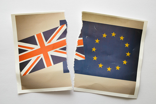 Image of a family snap photo showing the United Kingdom Union Jack and European Community flags - ripped in two as a divorce photo.