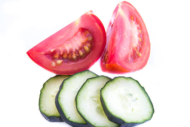 istock Cut tomato and cucumber isolated on white 540867246
