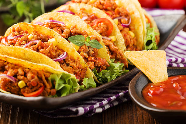 istock Tacos with meat and vegetables on wooden board 540867636