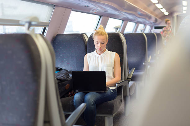 istock Woman travelling by train working on laptop. 540869228