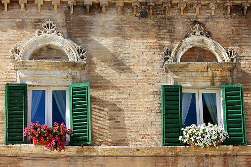 Two beautiful windows with flowers, in Ascoli Piceno, Marche, Italy
