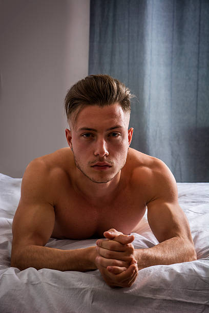 istock Shirtless sexy male model lying alone on his bed 540964244
