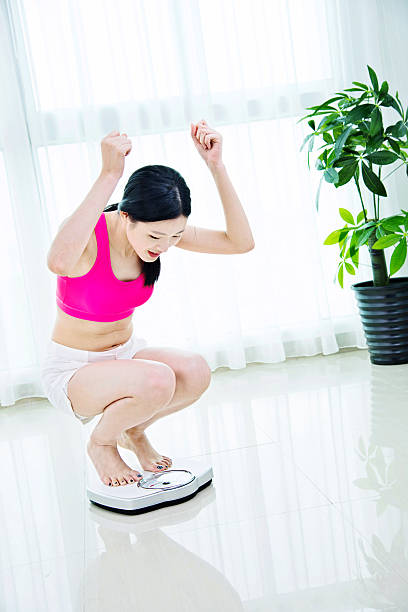istock Happy woman on weighing scale 540964968