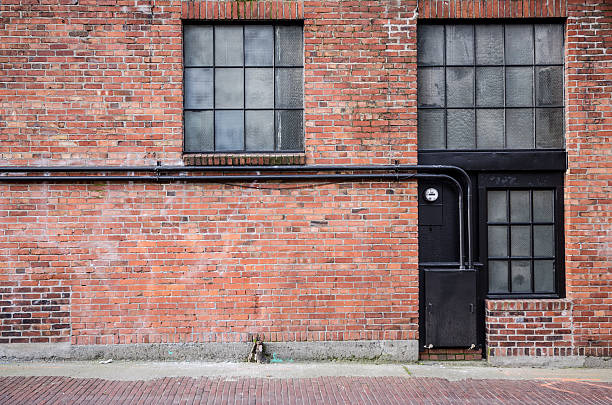 antiguo ladrillo alleyway con windows - callejuela fotografías e imágenes de stock