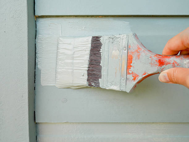 istock Hand holding brush painting wall 540968666