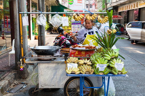 Bangkok, Thailand - April 24, 2016: Woman selling fruits on the street of Bangkok Chinatown.