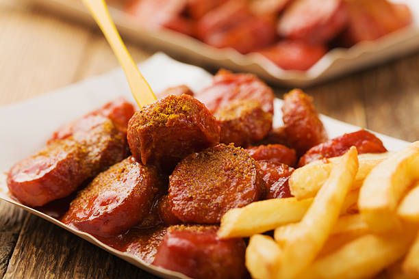 currywurst alemán tradicional, servido con patatas fritas sobre p desechable - currywurst fotografías e imágenes de stock