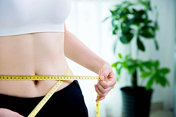 istock Young woman measuring her waist 540971894