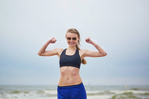 istock Young fitness running woman doing exercise on beach 540973276