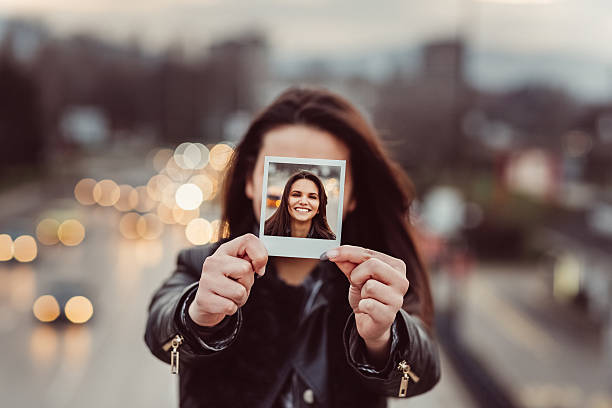 istock Young woman showing instant selfie 540974652