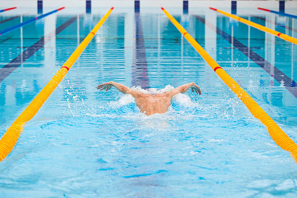 istock dynamic and fit swimmer in cap breathing performing the butterfly 540975068