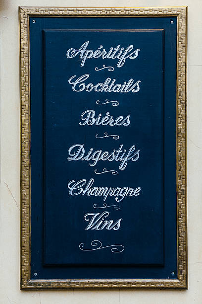 Menu board outside a French restaurant hand drawn french beverage restaurant placard, including cocktails, aperitifs, biers, appetizer, digestifs, champagne, vins, alcohol drinks, with elegant floral patterns and ornaments on black chalkboard and gold color wood frame on wall nice france restaurant stock pictures, royalty-free photos & images