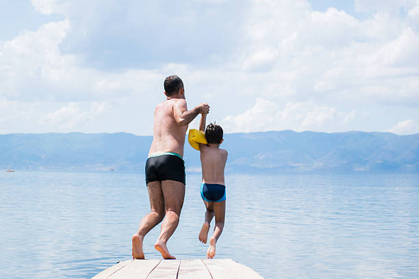 istock Father and son jumping into lake 540975996