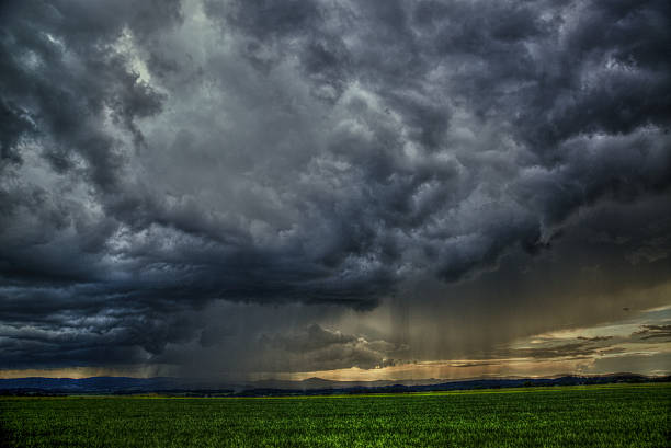 dramatic scene - meadow with clouds and rain stock photo