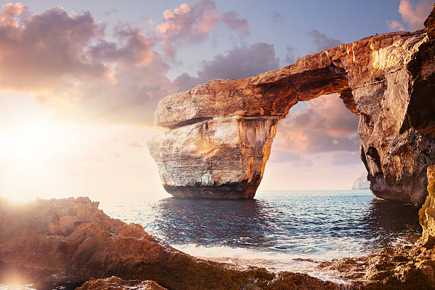 лазурный окно на закате, мальта - arch rock стоковые фото и изображения