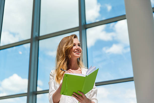 istock Young beautiful woman holding green notebook. 540984716
