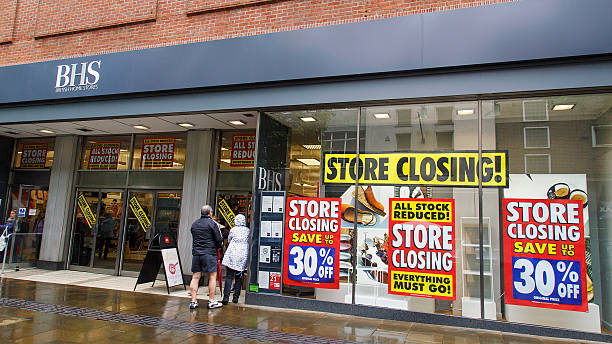 British Home Stores Swansea, UK: June 19, 2016: Shoppers enter a department store that is closing down. British Home Stores is a British department store chain with branches mainly located in high street locations or shopping centres. closing down sale stock pictures, royalty-free photos & images