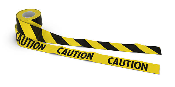 istock Striped Barrier Tape and CAUTION Tape Rolls unrolled across floor 540990888