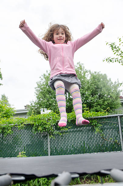 istock Young girl jumping on trampoline in backyard 540992238