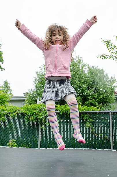 istock Young girl jumping on trampoline in backyard 540992354