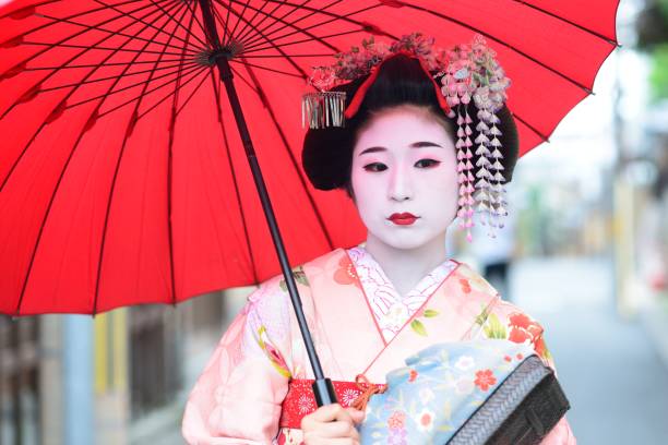 Young maiko in Kyoto A young maiko girl, a geisha in training, in the streets of Kyoto. modern geisha stock pictures, royalty-free photos & images
