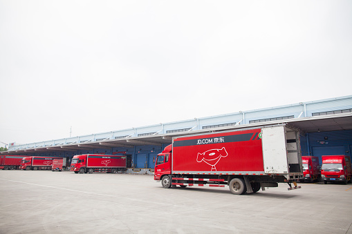 Gu'an, Сhina - June 14, 2016: JD.com trucks receiving incoming goods and preparing shipments at the Northeast China based Gu'an warehouse and distribution facility