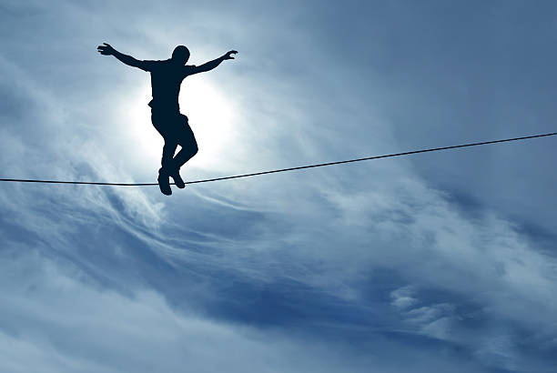 Man balancing on the rope Silhouette of man balancing on the rope concept of risk taking highlining stock pictures, royalty-free photos & images