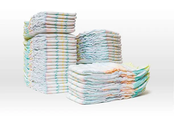 Photo of Stacked diapers isolated on white background.