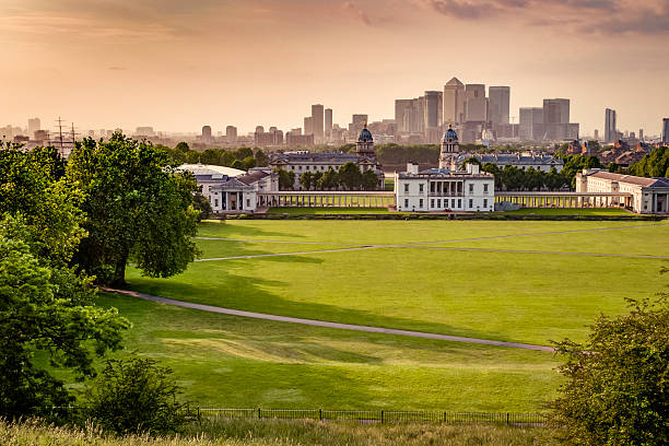 London's skyline seen from Greenwich park Panoramic View from the top of a hill in Greenwich Park in London, UK looking over the park, river Thames and Canary Wharf at sunset greenwich london stock pictures, royalty-free photos & images
