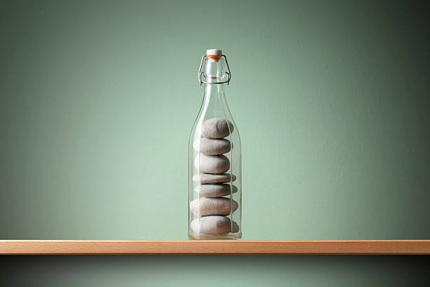 Balanced pebbles in the bottle. Concept image. Balanced pebbles in the bottle. illusion photos stock pictures, royalty-free photos & images